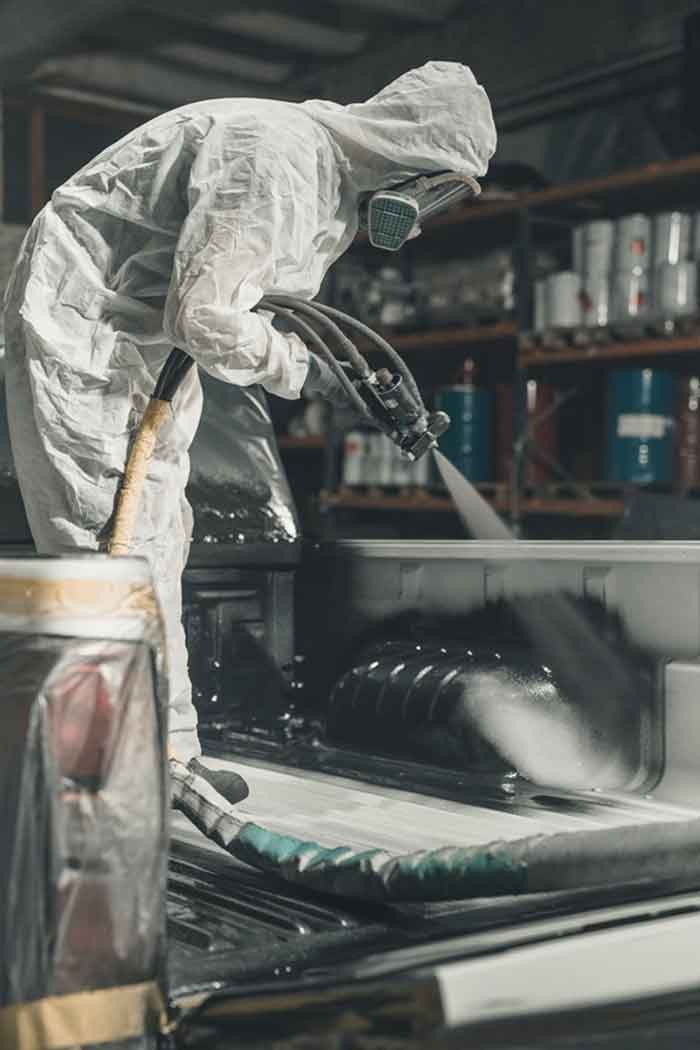 Spray-on bedliner being applied to a truck bed